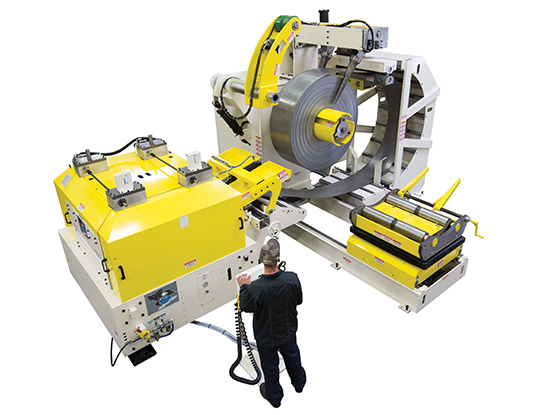 Coe Spacemaster Series 4 compact coil feed line with a yellow-and-gray decoiler holding a steel coil, integrated straightener/feeder, and an operator standing at the control pendant.